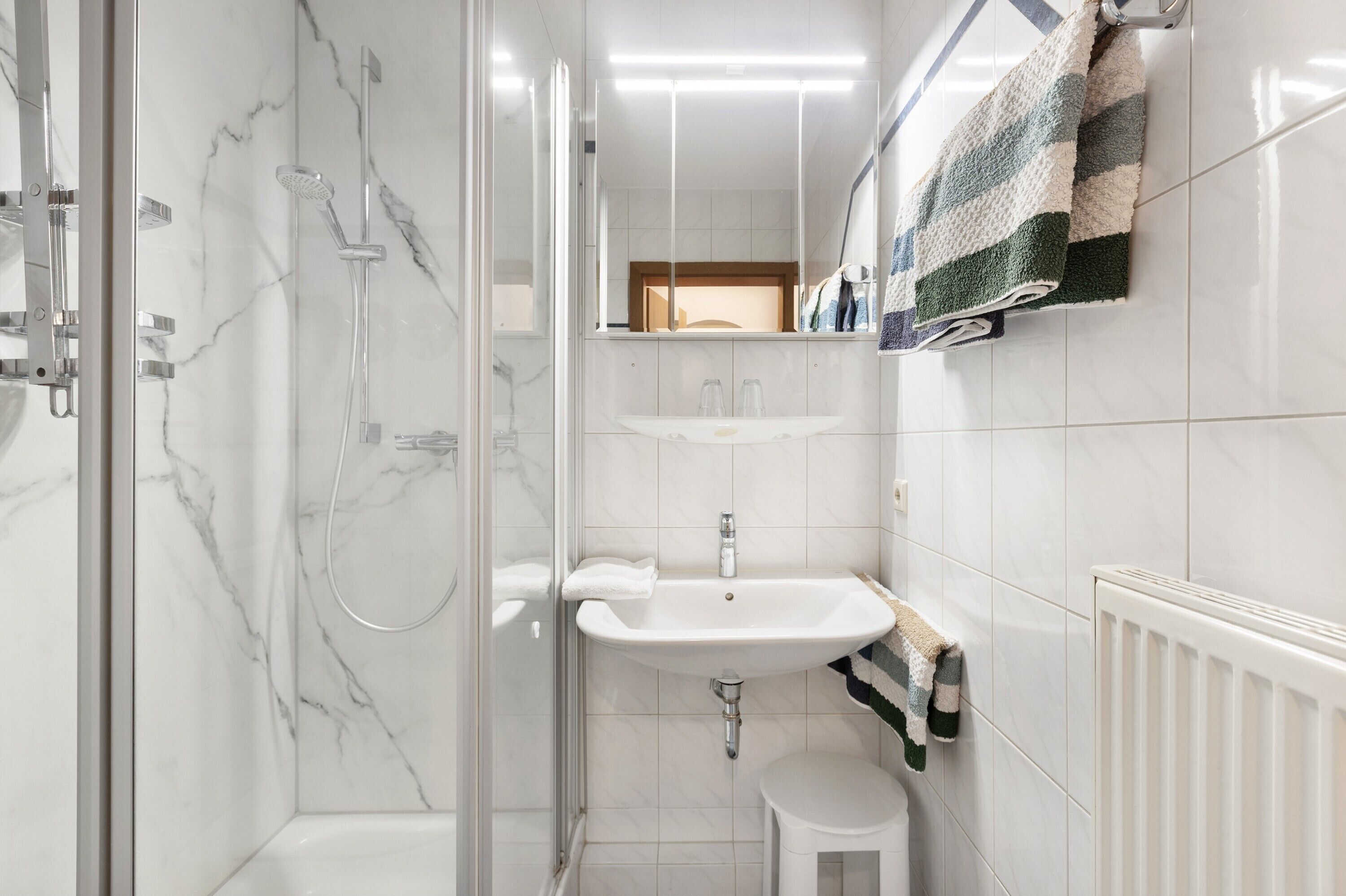 A bathroom with a shower, sink, and toilet.