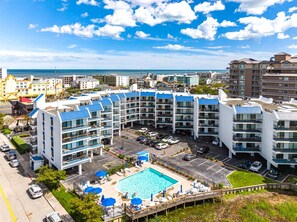 A multi-story hotel with a rooftop pool and a view of the ocean.
