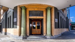 A building entrance with a double door, columns, and a small set of steps leading up to it. - Spacious 1bdr Fast Wi-fi Near RAC Arena (Perth)