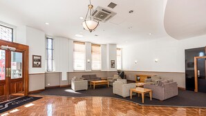 A spacious lobby with a herringbone wooden floor, comfortable seating areas, and large windows allowing natural light. - Spacious 1bdr Fast Wi-fi Near RAC Arena (Perth)