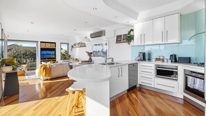 A modern kitchen with white cabinetry, a central island, and a built-in oven. - Designer Luxury 3brd - Epic Views - South Perth (Perth)