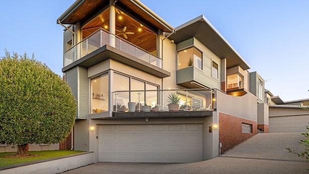 A modern two-story house with a garage, large windows, and a balcony with potted plants. - Designer Luxury 3brd - Epic Views - South Perth (Perth)