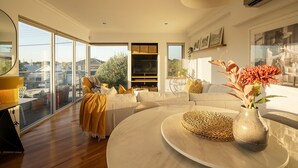 A modern living room with a large window, a round coffee table, and a sofa. - Designer Luxury 3brd - Epic Views - South Perth (Perth)