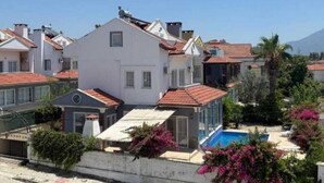 Zona residencial con casas, piscina y cielo despejado.