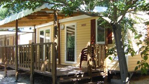 A wooden deck leading to a house with a porch, a door, and a window. - ZEcamping 4* familial piscine chauffée dog friendly locatif TV LV clim (Rochegude)