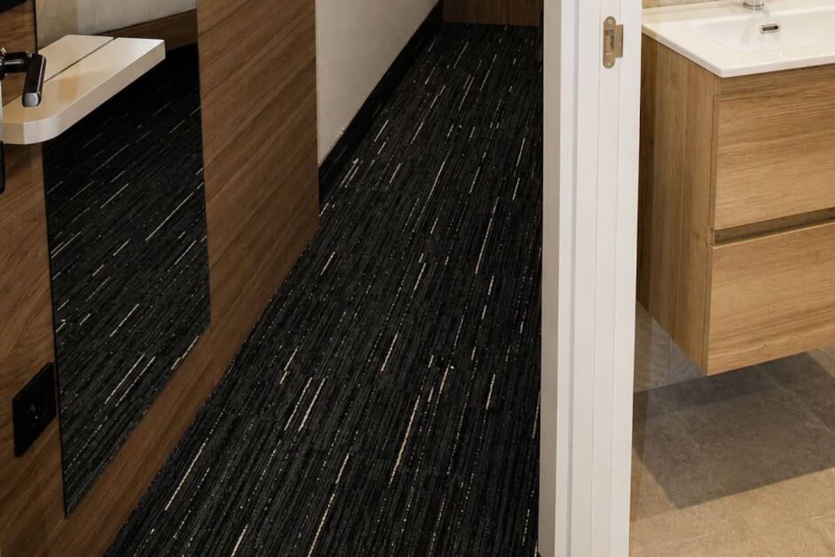 A modern bathroom with a wooden vanity, a mirror, and a shower area.
