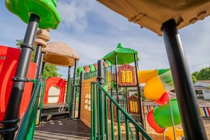 A playground with various play structures including slides and climbing areas.
