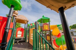 A playground with various play structures including slides and climbing areas.