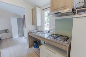 A compact kitchen with a gas stove, a sink, and a window.
