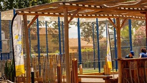 A covered outdoor seating area with wooden benches and a pergola structure.