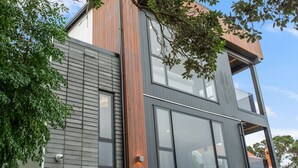 A modern two-story building with large windows and a wooden accent wall.