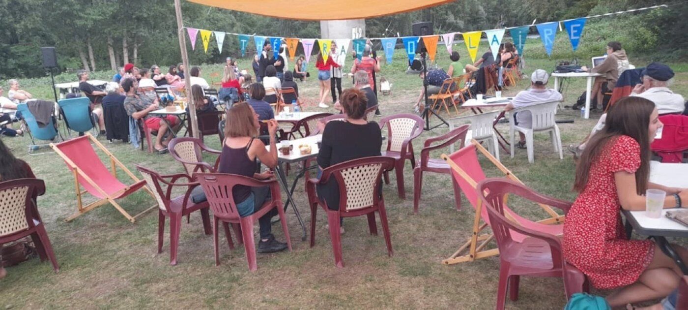 An outdoor gathering with people seated at tables under a canopy, surrounded by chairs and tables.