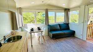Una cocina moderna con comedor, sofá y ventanas amplias.