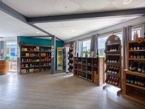 Un negozio spazioso con scaffali in legno pieni di prodotti assortiti e bottiglie di vino.