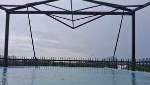 Una piscina con una estructura de pérgola de metal por encima.