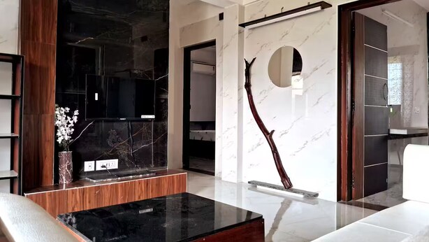 Una sala de estar moderna con una chimenea de mármol negro, una mesa de centro de madera y un sofá blanco.