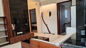 Un baño moderno con tocador de madera, espejo y encimera de mármol.