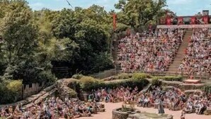 Un vaste amphithéâtre en plein air, doté de gradins et d’une scène centrale.