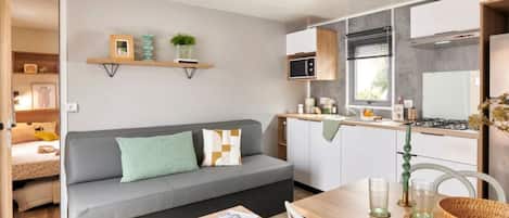 Een knus woongedeelte met een bank, een eettafel en een kitchenette.