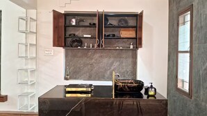 Eine moderne Küche mit schwarzem Arbeitsplatz, einem eingebauten Backofen und einem Holzschrank darüber.