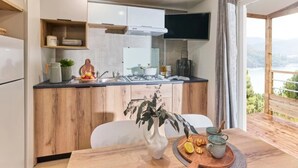Une cuisine moderne avec des meubles en bois, une cuisinière encastrée et un coin repas avec une table mise pour deux personnes.