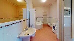 Un baño con lavamanos, inodoro, bidé y lavadora.