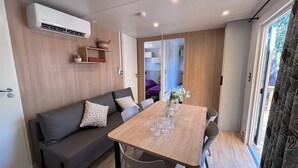 Un espace de vie compact comprenant un canapé, une table à manger et un petit coin cuisine.