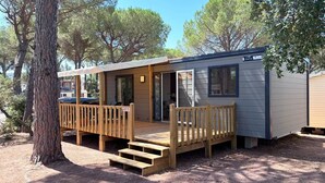 Une petite cabane avec une terrasse en bois, un porche couvert et une porte coulissante.