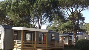 A mobile home with a wooden deck and a small porch.