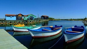 A calm waterfront with several small boats docked at a wooden pier. - ZEcamping 4 étoiles piscine chauffée animations fitness locatif 17m2 (Saint-Trojan-les-Bains)