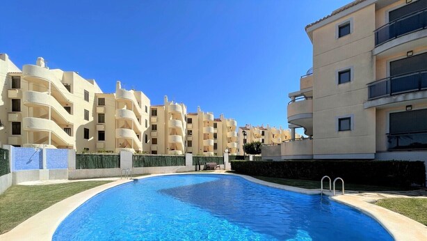 Una piscina rodeada de edificios de apartamentos con balcones.
