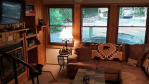 A cozy living room with a fireplace, a sofa, a coffee table, and a lamp.