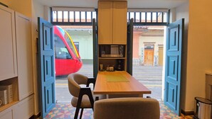 Una cocina compacta con comedor, que presenta un suelo de baldosas geométricas coloridas, una mesa de madera y dos sillas.