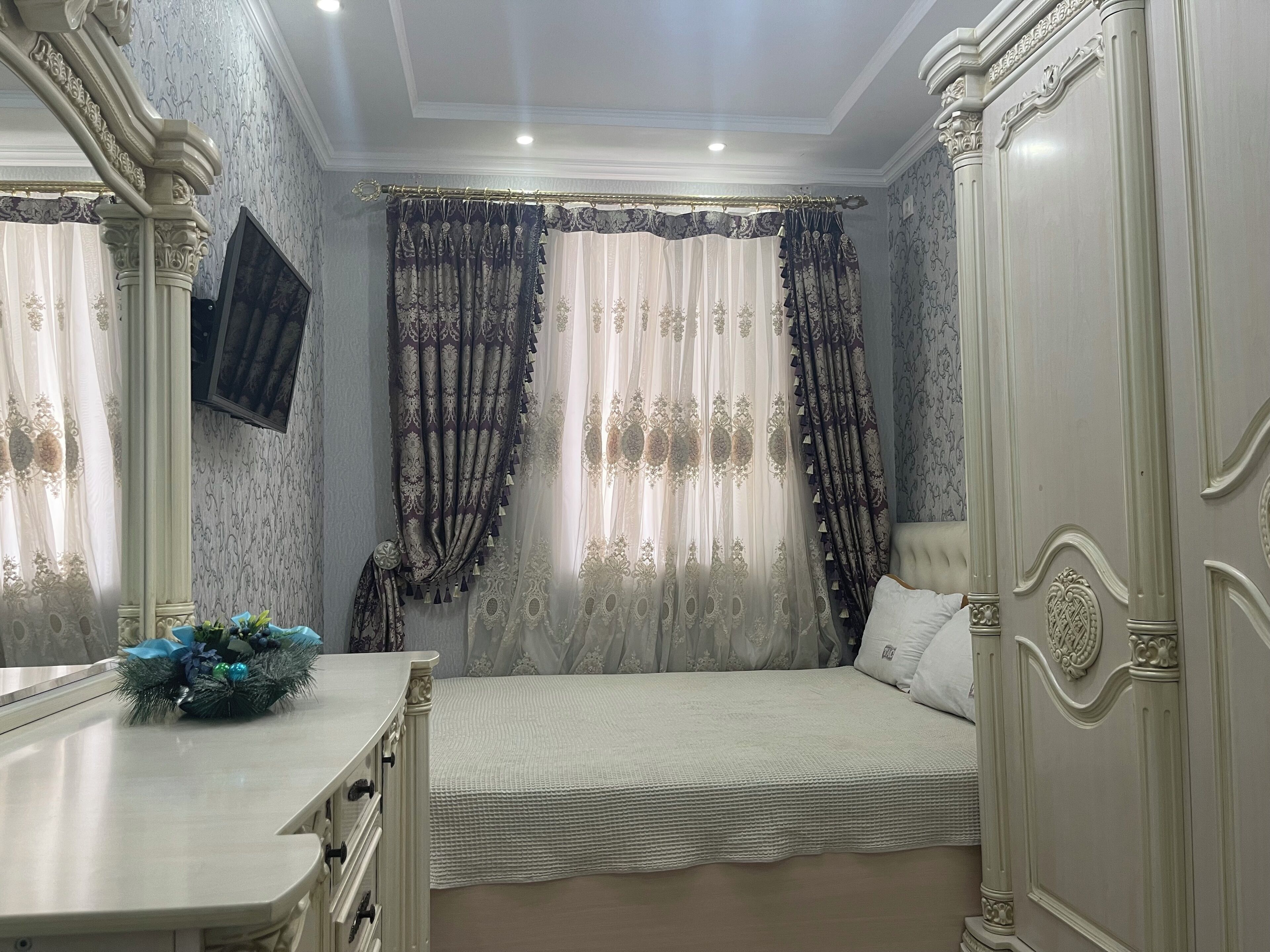 A bedroom with a bed, a dresser, and a mirror.