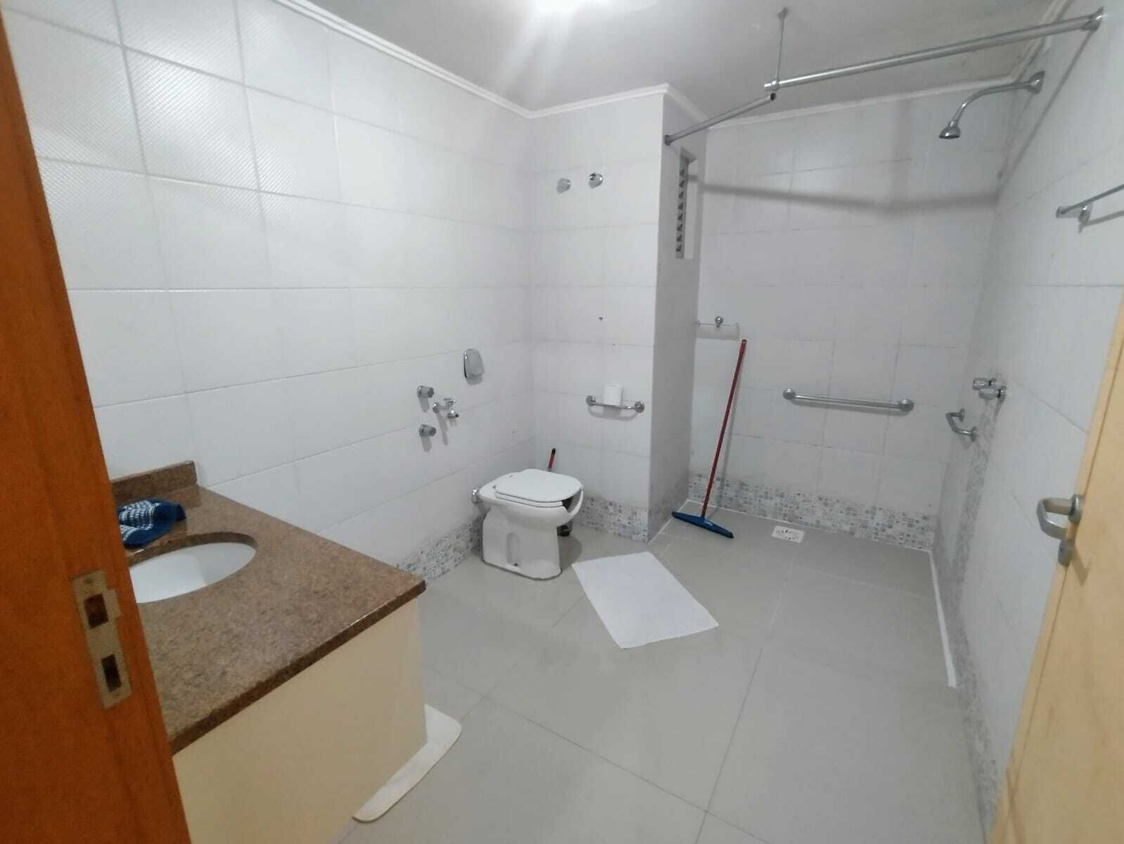 Un baño con inodoro, lavamanos y zona de ducha.