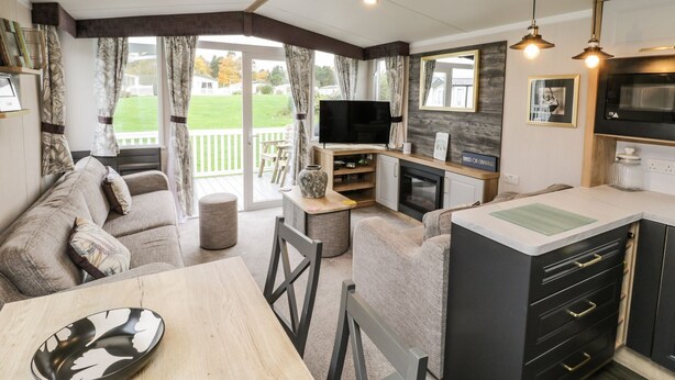 A compact, modern living space with a sofa, dining table, and kitchen area. - Kelly's Retreat (Scarborough)