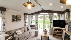 A cozy living area with a sofa, TV, and dining table. - Kelly's Retreat (Scarborough)