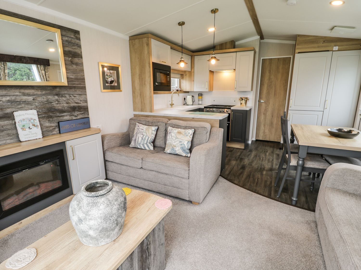 Un espacio habitable compacto con kitchenette, sofá, mesa de comedor y chimenea.