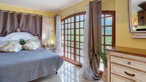 A bedroom with a bed, curtains, a dresser, and a window with a view. - Lemon Green Apartment (Celle Ligure)
