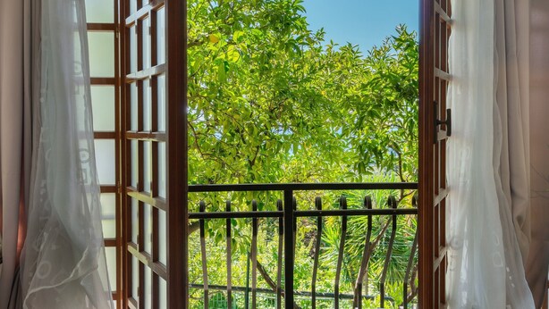 An open window with a view of lush green trees and a balcony railing. - Lemon Green Apartment (Celle Ligure)