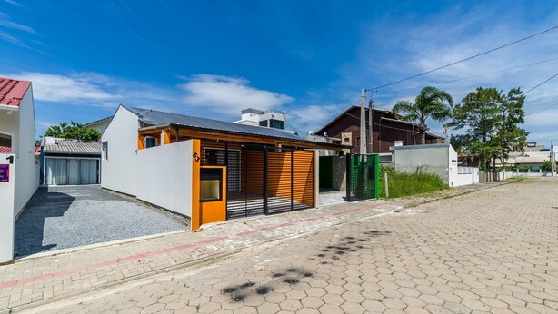Una casa moderna amb garatge, un petit porxo i un vial pavimentat.