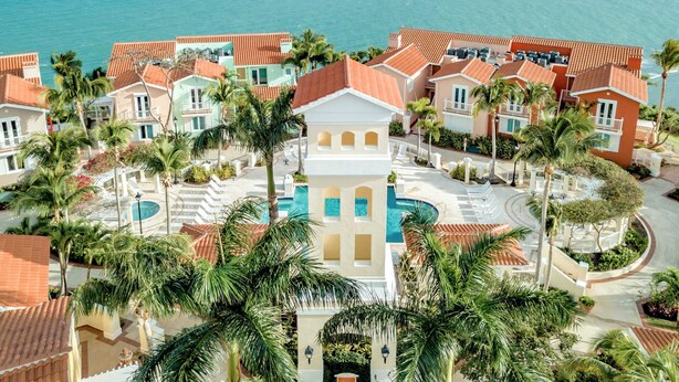 A resort with a central pool, palm trees, and ocean views. - Brisas Del Mar | Stunning Views & Best Location (Fajardo)