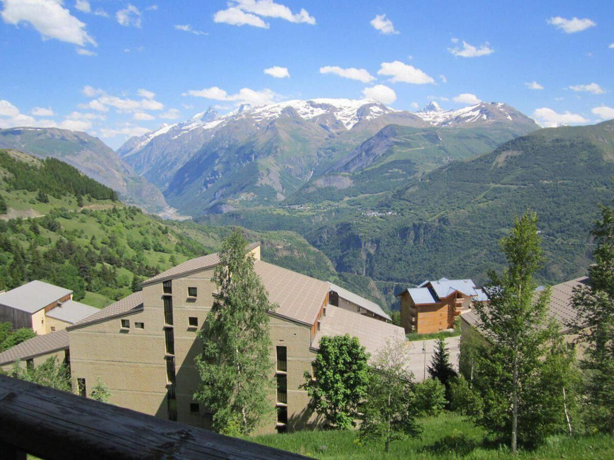 A mountainous landscape with buildings in the foreground.