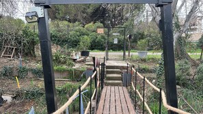 A wooden bridge with rope handrails leading to a gated entrance. - Guest Room with Lake View, Wi-Fi, and Air Conditioning (Arles)