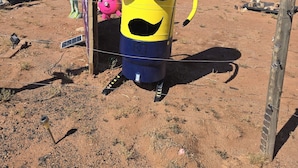 A large yellow inflatable character with a mustache and green goggles in a desert setting. - Alien Acres UFO campground,  car, truck, RV, tent off-grid camping (Sunvalley)