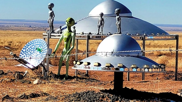 A desert landscape with a large metallic structure featuring several domes and alien statues. - Alien Acres UFO campground,  car, truck, RV, tent off-grid camping (Sunvalley)