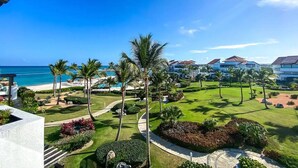 Un resort con piscina, palmeras y vista al océano.