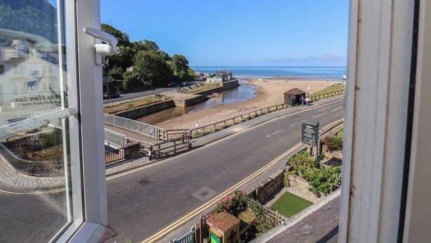 A coastal road with a beach and a stone wall. - Woodbine Cottage (Whitby)
