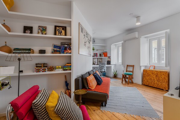 A modern living room with a sofa, a coffee table, and a bookshelf.