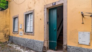 Un bâtiment avec une porte verte, une enseigne portant le chiffre « 9 » et un coffret électrique fixé au mur.